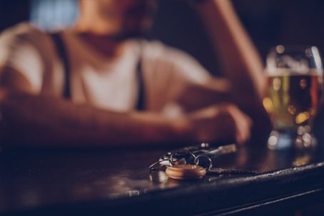 Man sitting at bar with car keys beside him